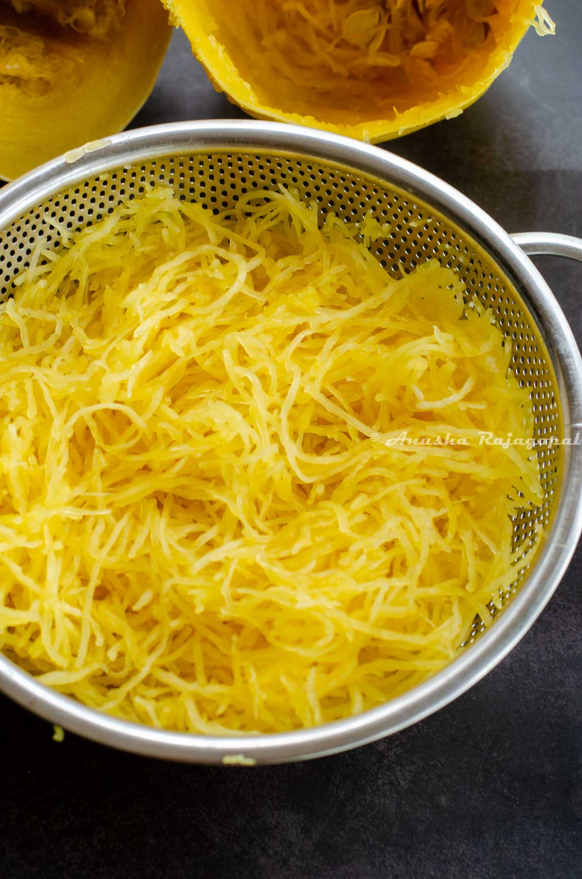 spaghetti squash cooked and cooled in a metal colander