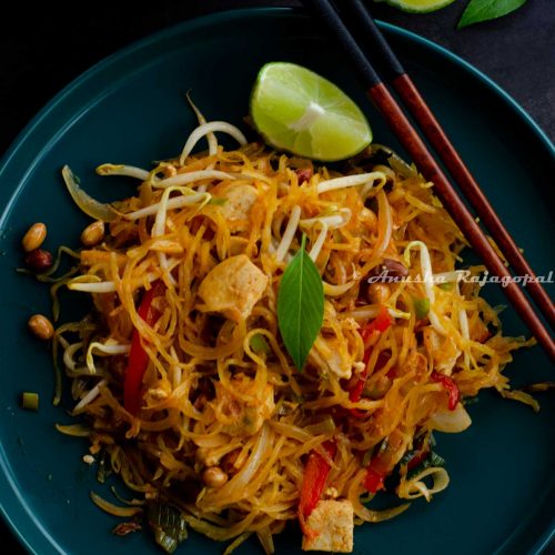 Spaghetti Squash Pad Thai served on a teal blue plate with a lime wedge and chopsticks