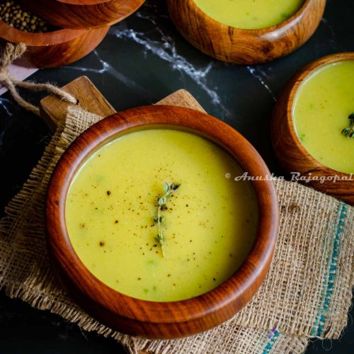 Instant pot cauliflower soup garnished with thyme and served in wooden bowls placed on a burlap mat.