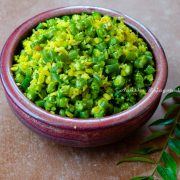 green beans poriyal served in a reddish brown bowl with curry leaves by the side