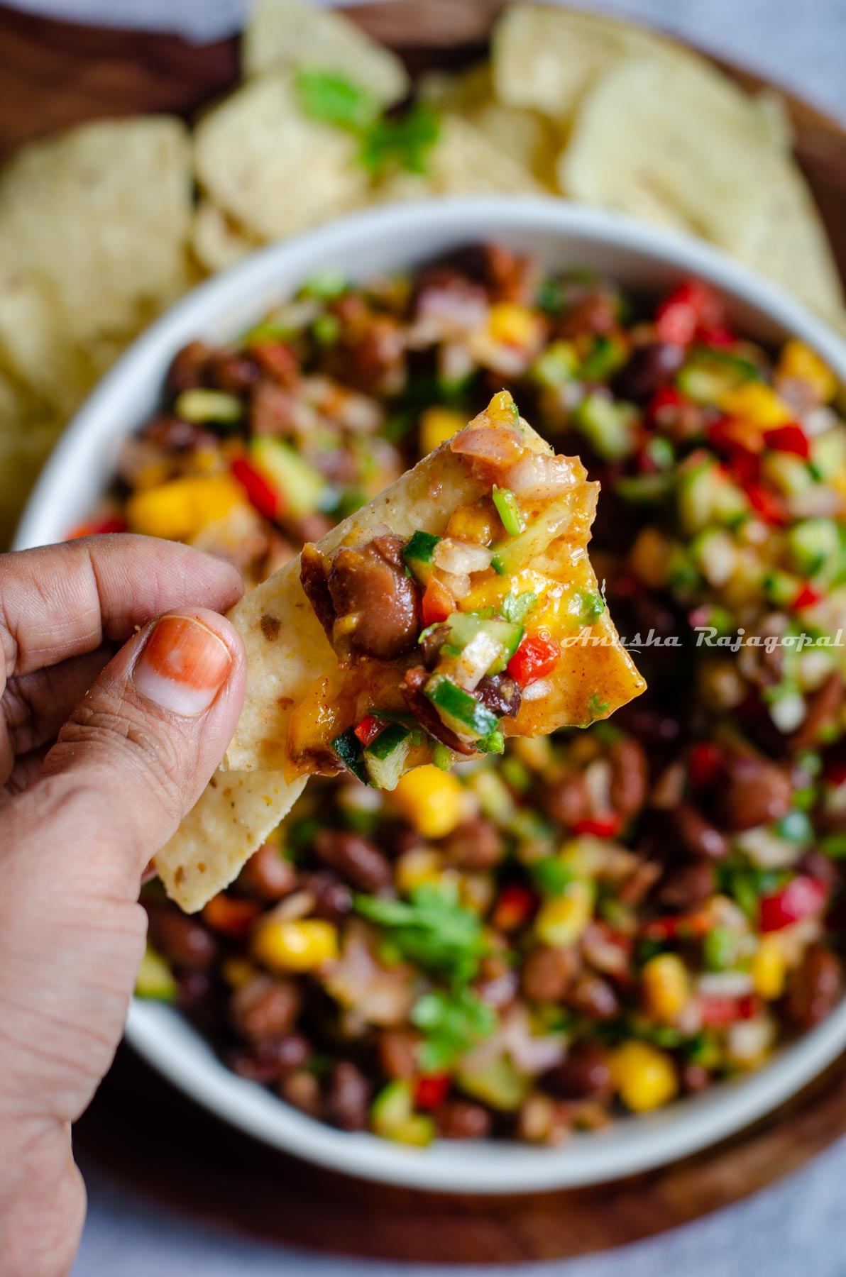 a tortilla chip topped with black bean and mango salad