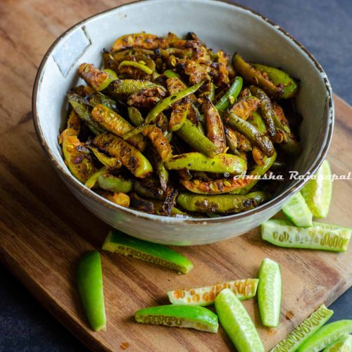 Kovakkai fry served in a beige ceramic bowl placed over a wooden board. Sliced kovakkai scattered around the bowl on the board