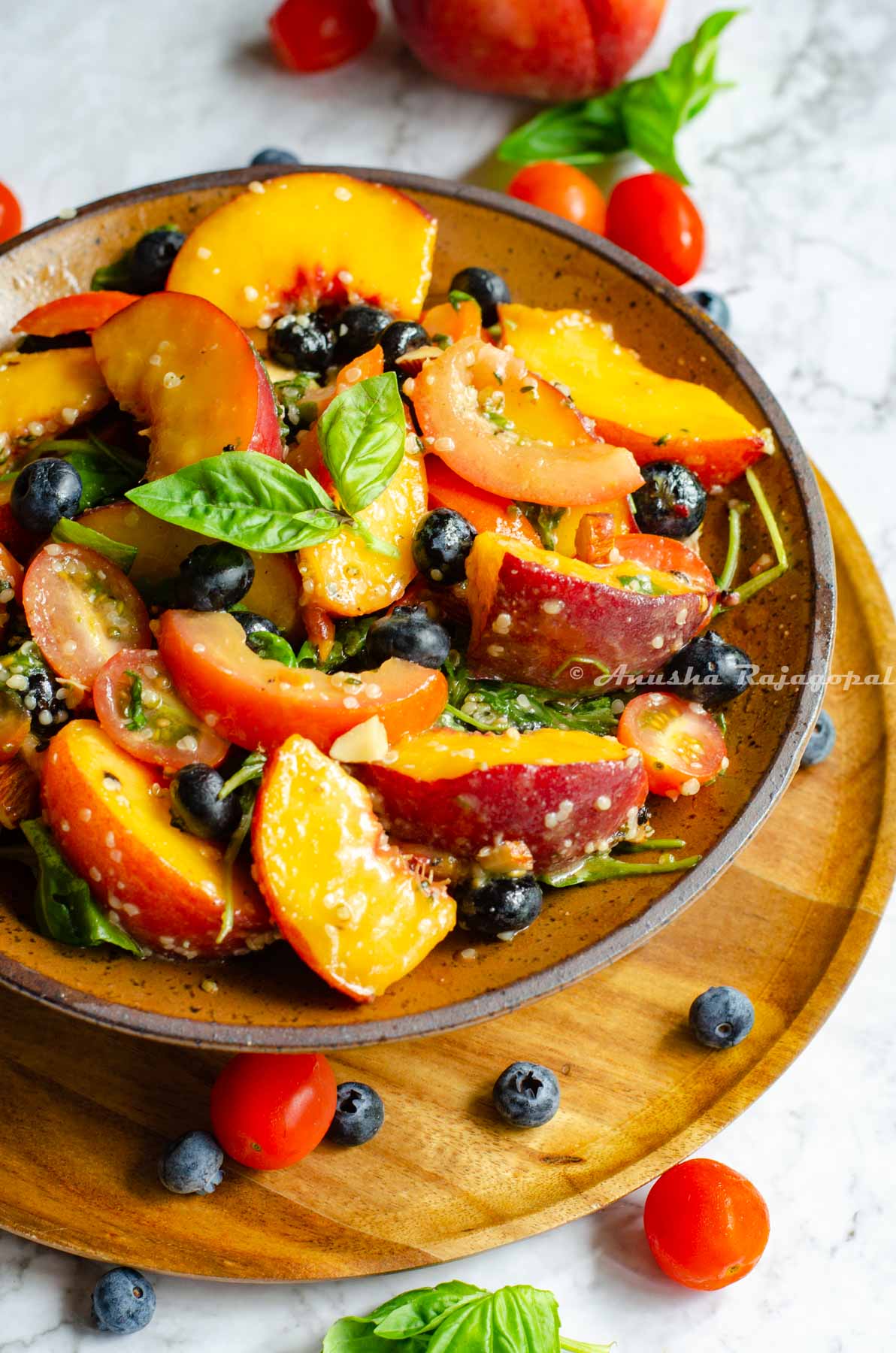 easy peach salad with summer fruits served in a brown shallow bowl