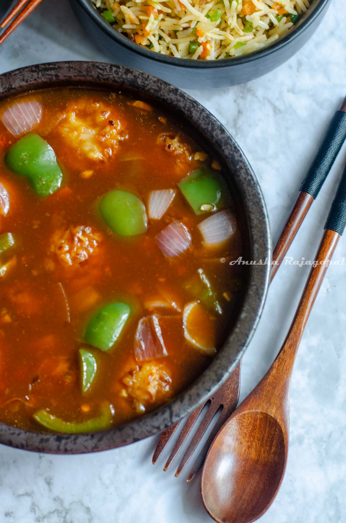 Veg manchurian balls in a gravy served in a black bowl