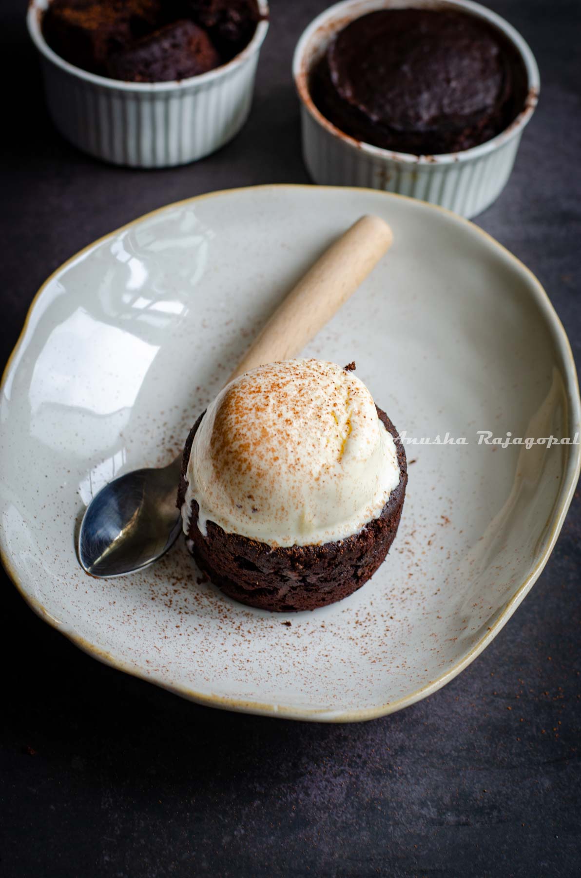 Choco lava cake with vanilla ice cream served on a plate with chocolate dusting