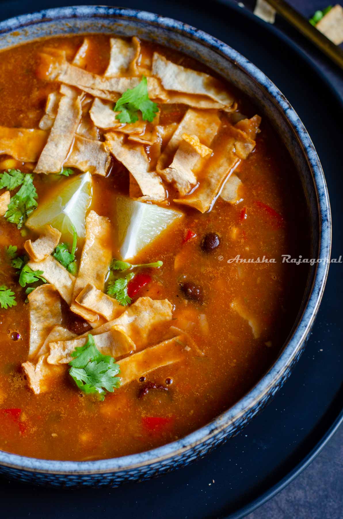 vegetarian black bean tortilla soup garnished with cilantro in a bowl