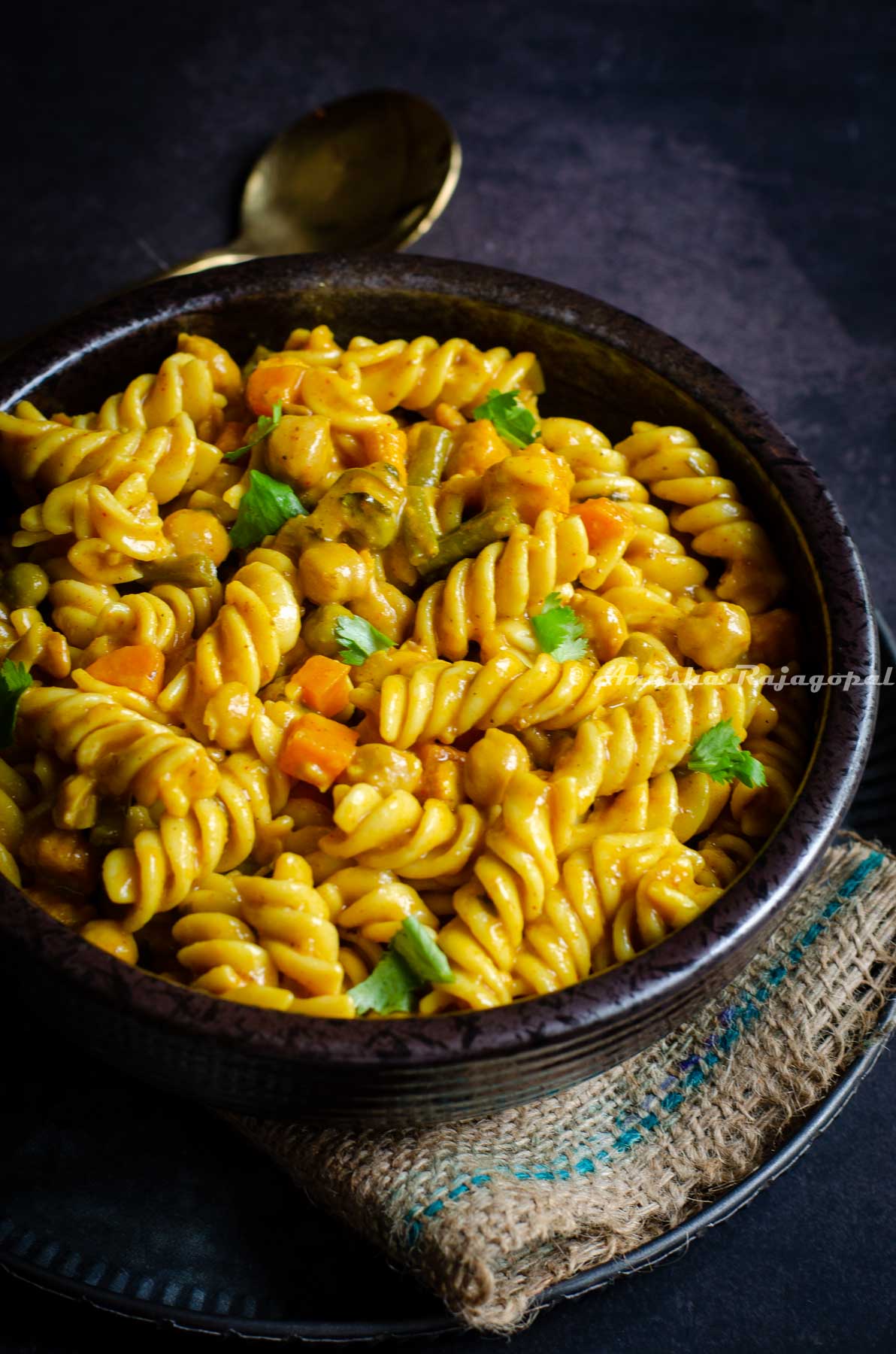 One pot healthy creamy curry pasta served in a black bowl.