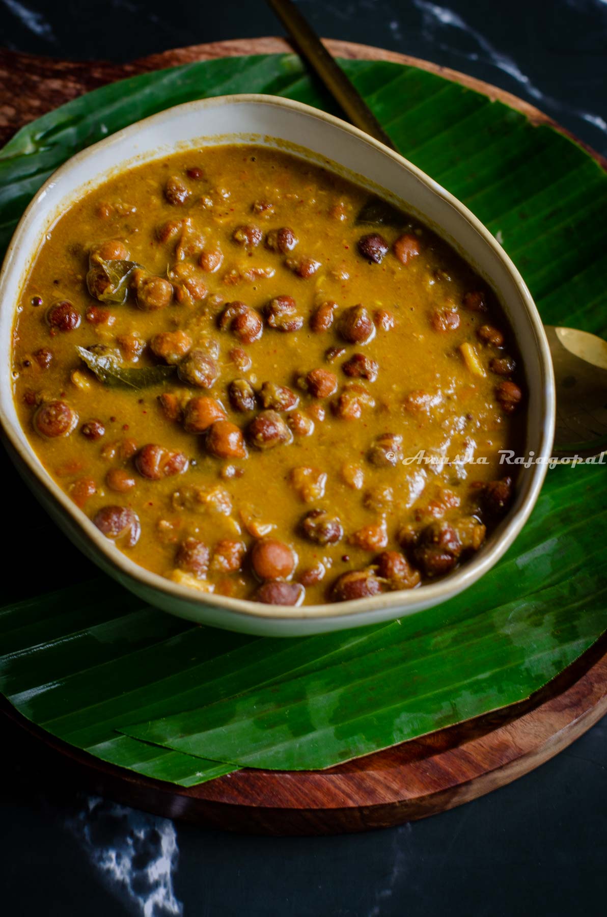 South Indian style brown chickpeas curry served in a beige bowl