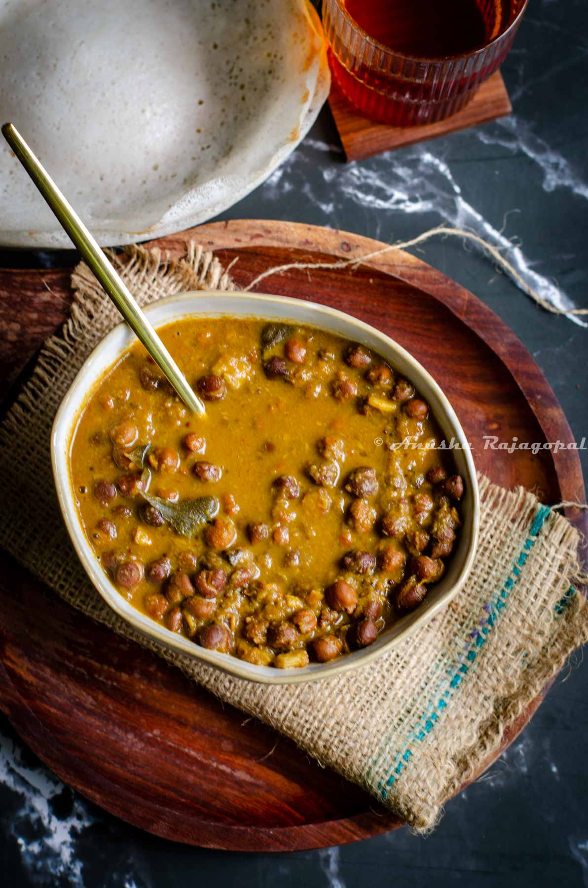 A bowl of delicious South Indian style Kerala Kadala Curry served with hoppers and tea