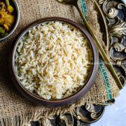 Instant pot brown basmati served in a black bowl on a rustic platter.